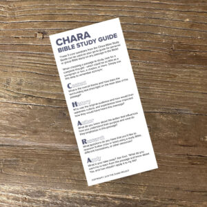 A printable CHARA Bible Study Guide Bookmark (PRINTABLE) rests on a wooden surface, clearly displaying five essential questions—Context, History, Author, Research, Apply—each accompanied by brief explanations designed to enrich your Bible study experience.