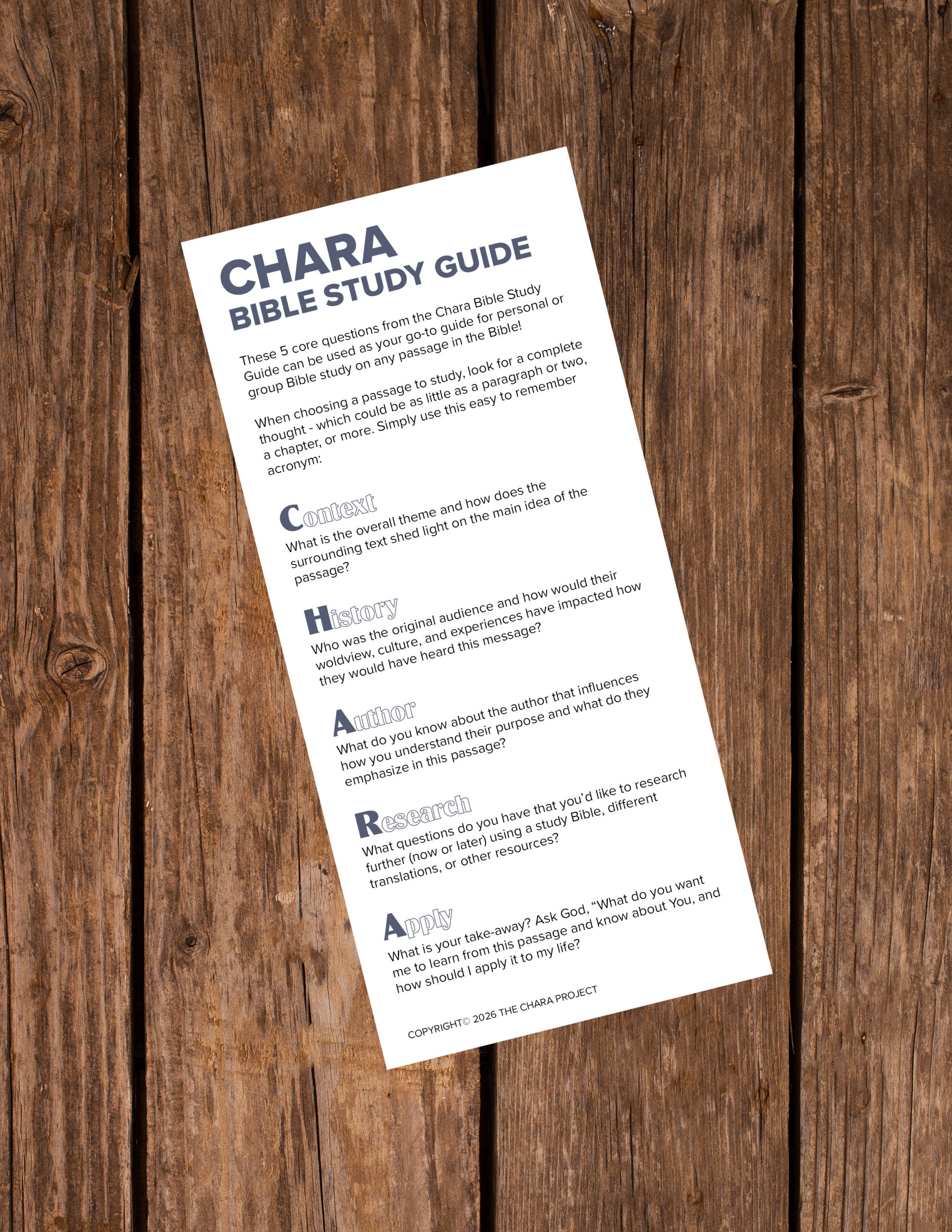 A printed Bible study guide titled “CHARA Bible Study Guide” with reflection questions, placed on a wooden surface. The guide organizes questions under sections: Context, Hear, Apply, Research, and Apply. Includes a Free Chara Bookmark to enhance your study experience.