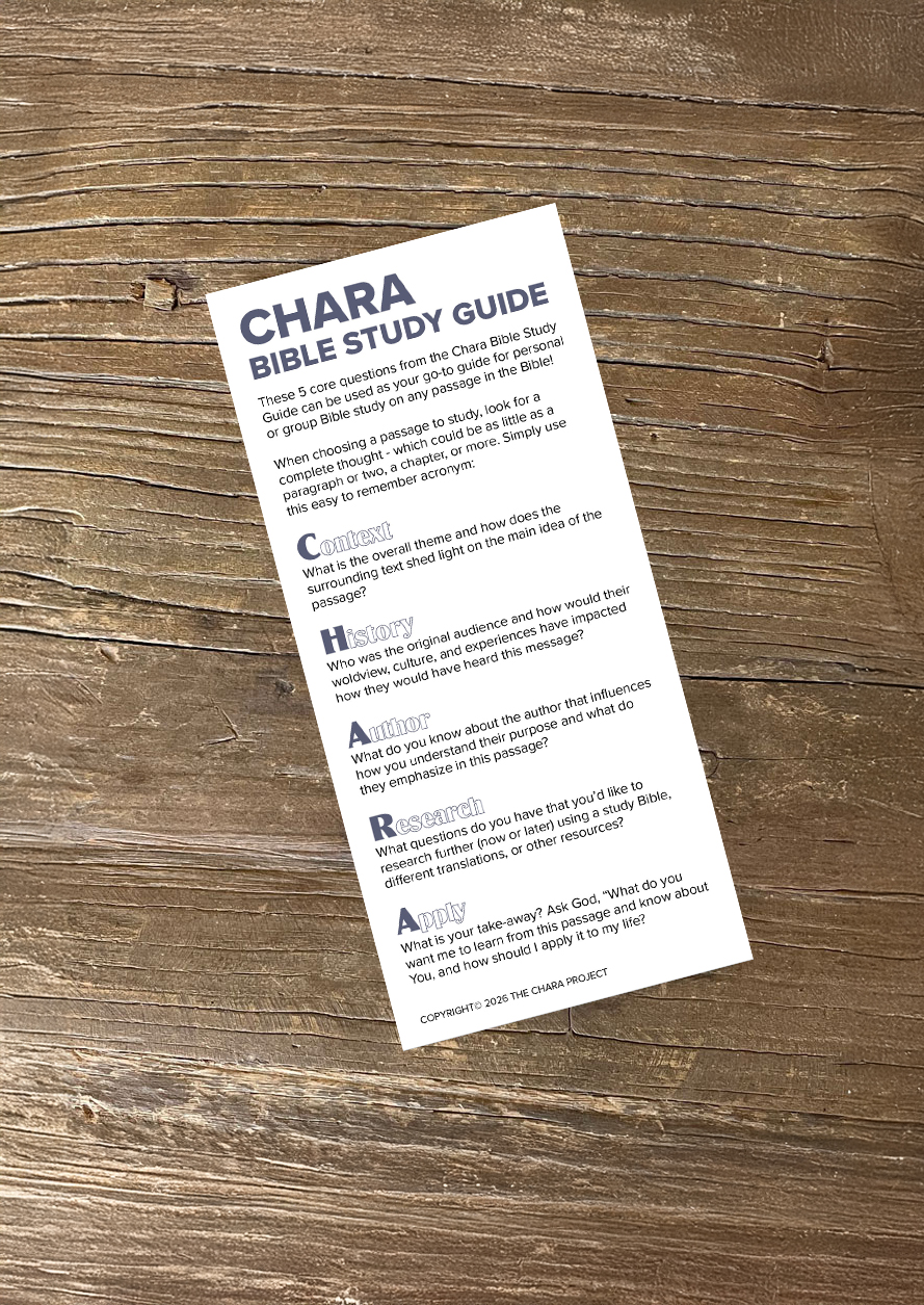 A CHARA Bible Study Guide flyer rests on a wooden surface, outlining steps: Context, History, Author, Research, and Application, with brief questions and tips under each section for Bible study. Included is information about a Free Chara Bookmark to help enhance your study experience.
